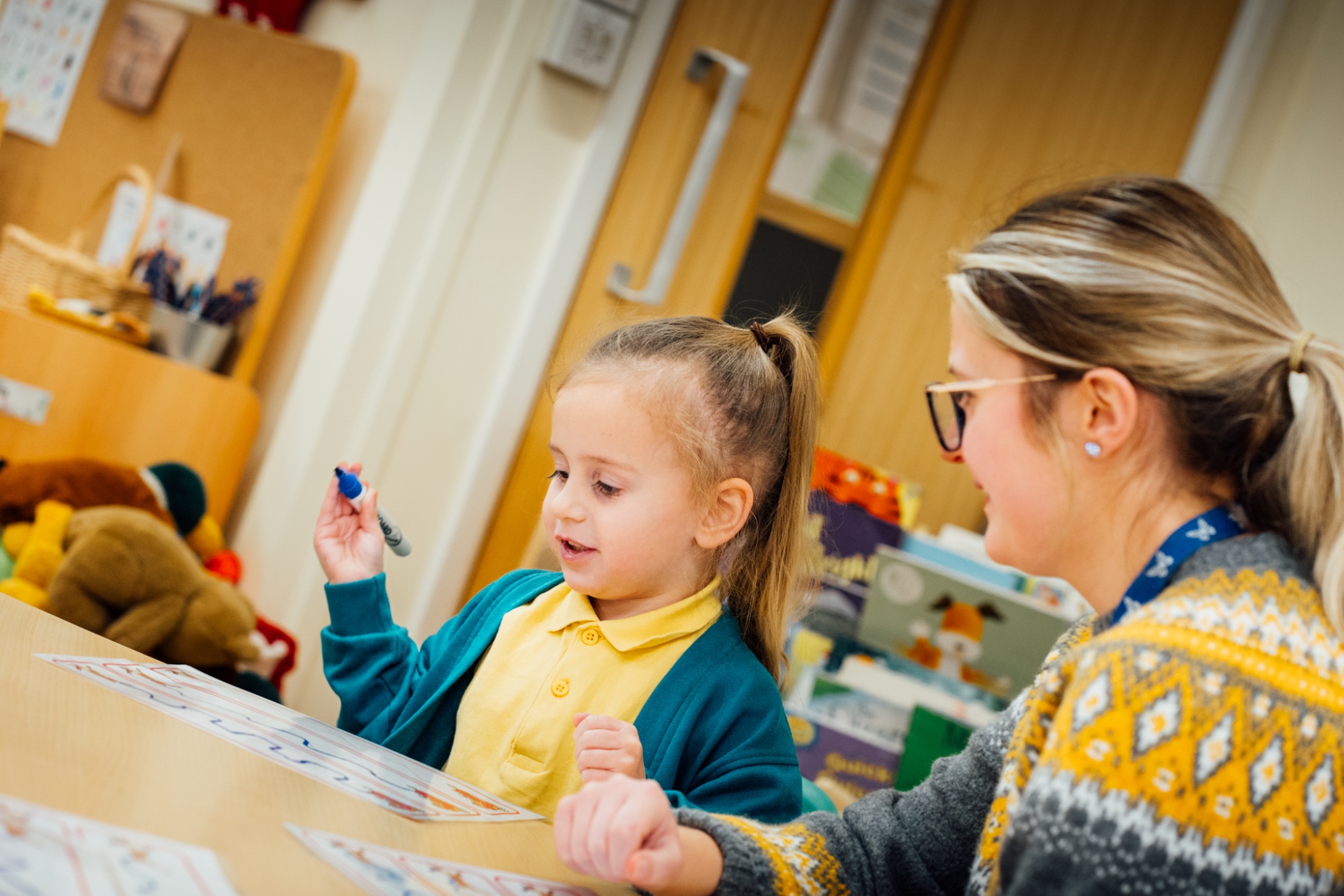 teacher working with child in lesson