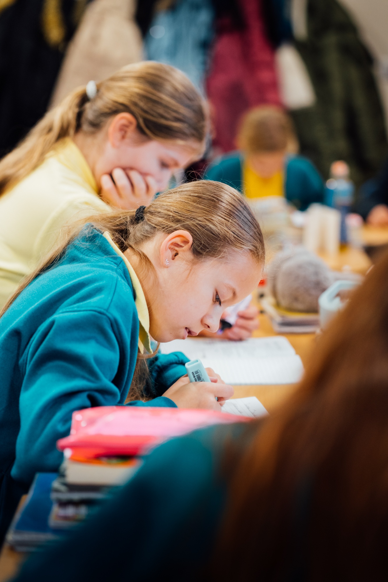 students working in classroom and writing in text book