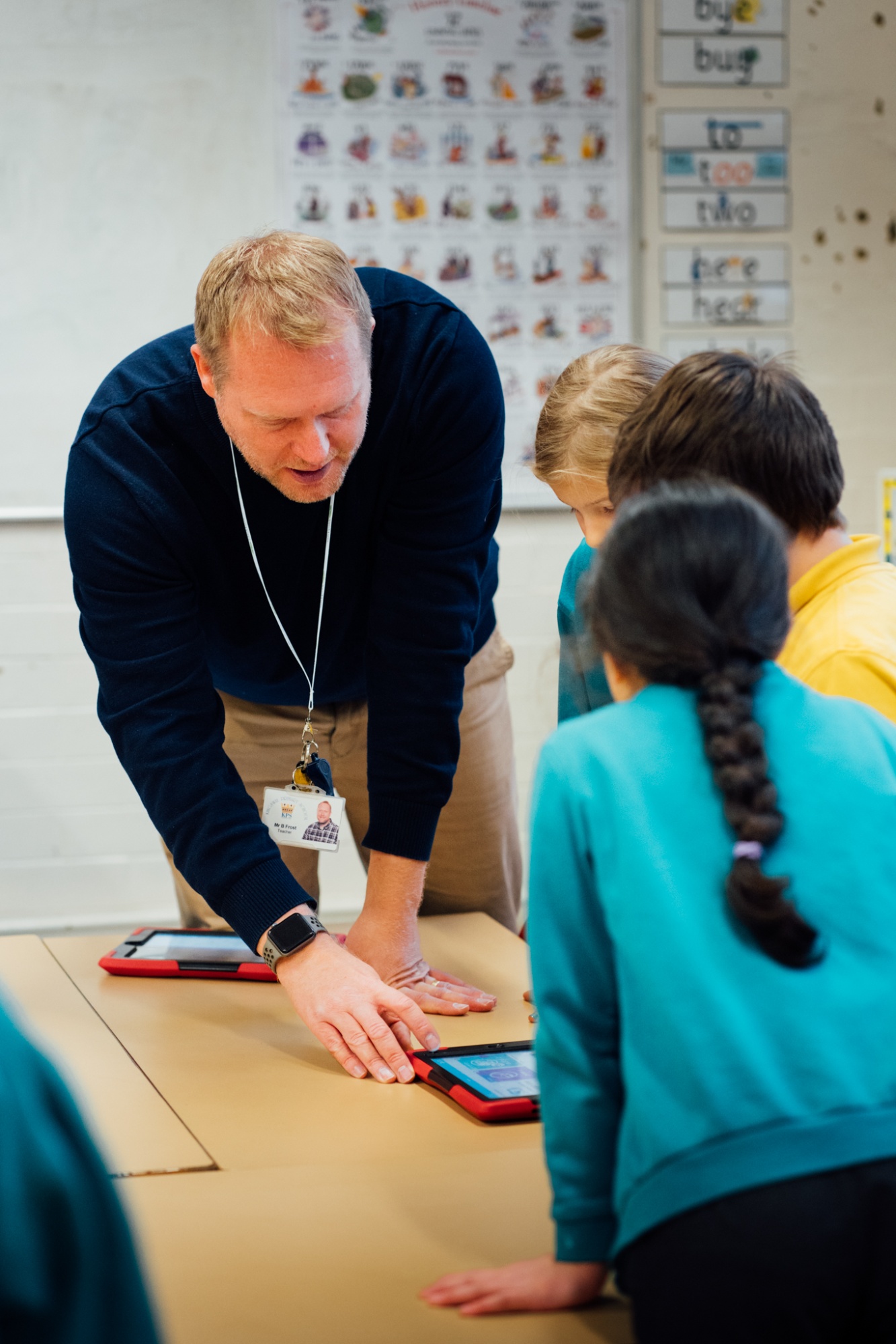 teacher working with a group of students on the iPad
